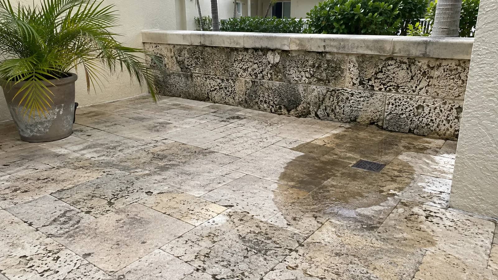 Weathered travertine and coral stone paving around a South Florida courtyard in daylight