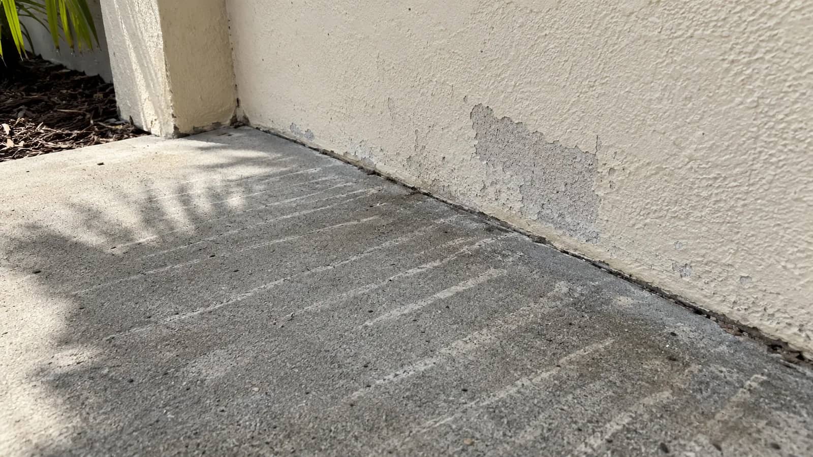 Close view of etched lines left in concrete and stucco by an overly narrow pressure-washer spray